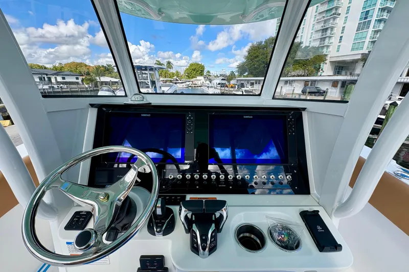Slide: The Image of 2026 NauticStar 332 Offshore helm with dual screens and modern controls. - 4