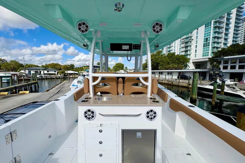 Slide: The Image of 2026 NauticStar 332 Offshore boat interior with modern amenities at a marina. - 6