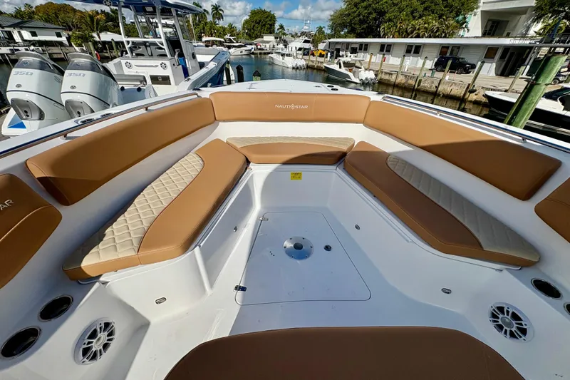 Slide: The Image of 2026 NauticStar 332 Offshore boat with tan seating, docked in a marina. - 9