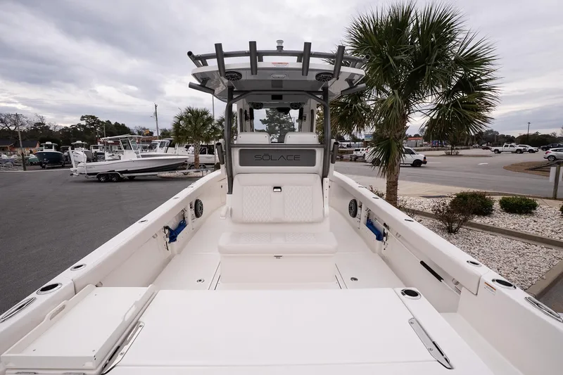 Slide: The Image of 2026 Solace 28 HCS boat, spacious deck, modern design, parked near palm trees. - 10