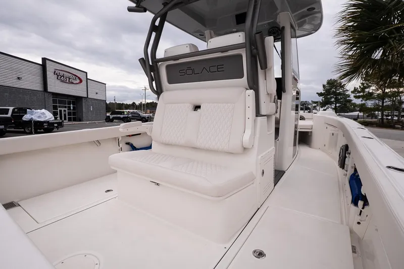 Slide: The Image of 2026 Solace 28 HCS boat interior with seating, docked near dealership. - 11