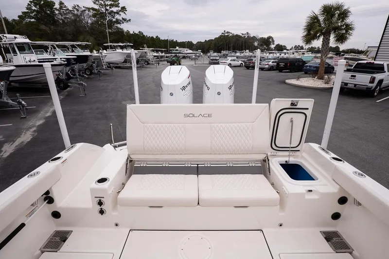 Slide: The Image of 2026 Solace 28 HCS boat interior with seating and storage, parked in a marina. - 15