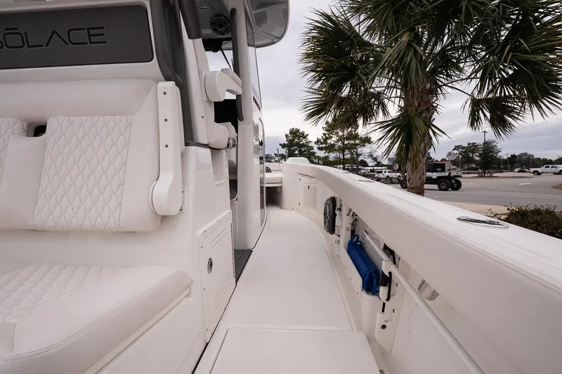Slide: The Image of 2026 Solace 28 HCS boat interior with white seating and palm tree background. - 20