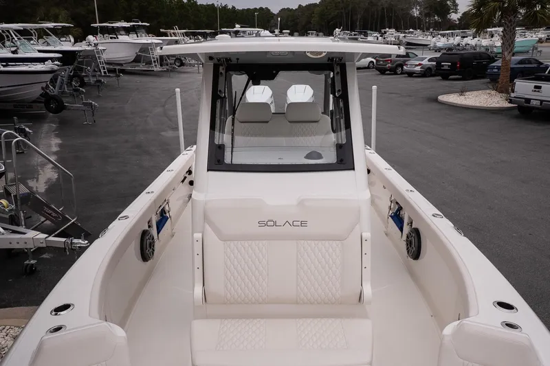 Slide: The Image of 2026 Solace 28 HCS boat in a marina, showcasing sleek design and spacious seating. - 26