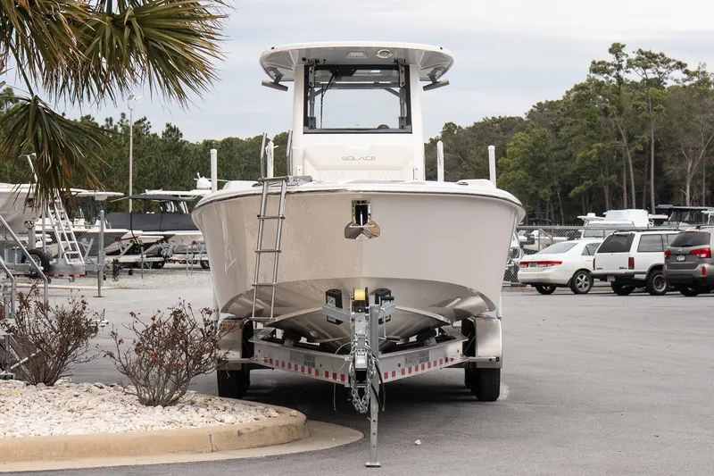 Slide: The Image of 2026 Solace 28 HCS boat on trailer in parking lot, surrounded by trees and vehicles. - 3