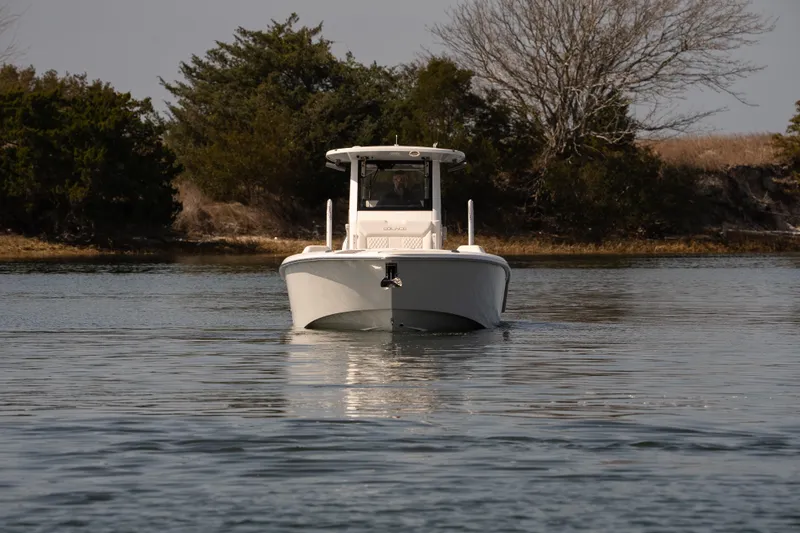 Slide: The Image of 2026 Solace 28 HCS boat cruising on calm water with trees in the background. - 35