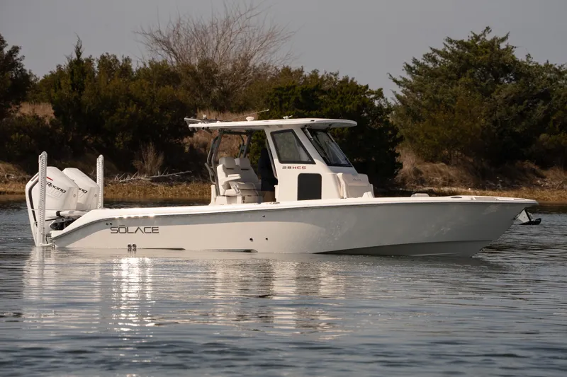 Slide: The Image of 2026 Solace 28 HCS boat on calm water, surrounded by trees. - 37