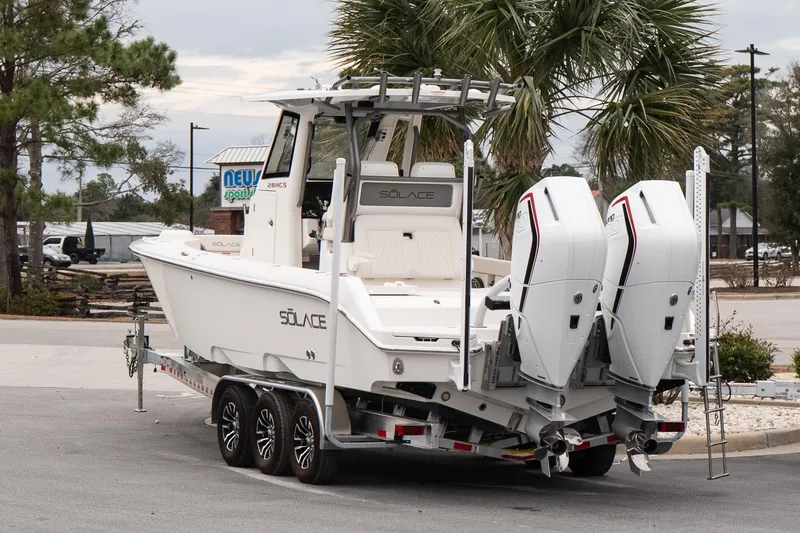 Slide: The Image of 2026 Solace 28 HCS boat on trailer with dual engines, parked near palm trees. - 4