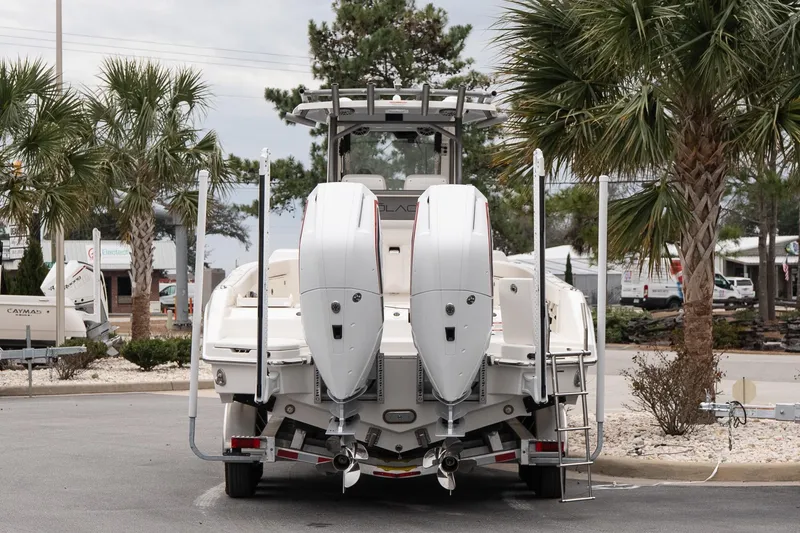 Slide: The Image of 2026 Solace 28 HCS boat with dual engines, parked near palm trees. - 5