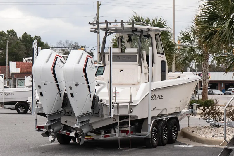Slide: The Image of 2026 Solace 28 HCS boat with dual engines on a trailer, parked outdoors. - 6