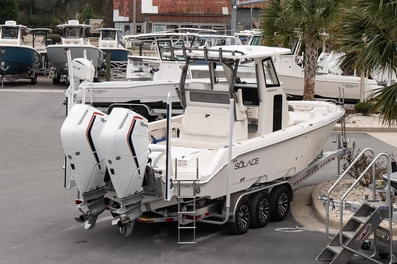 Slide: The Image of 2026 Solace 28 HCS boat with twin engines on a trailer in a marina. - 7