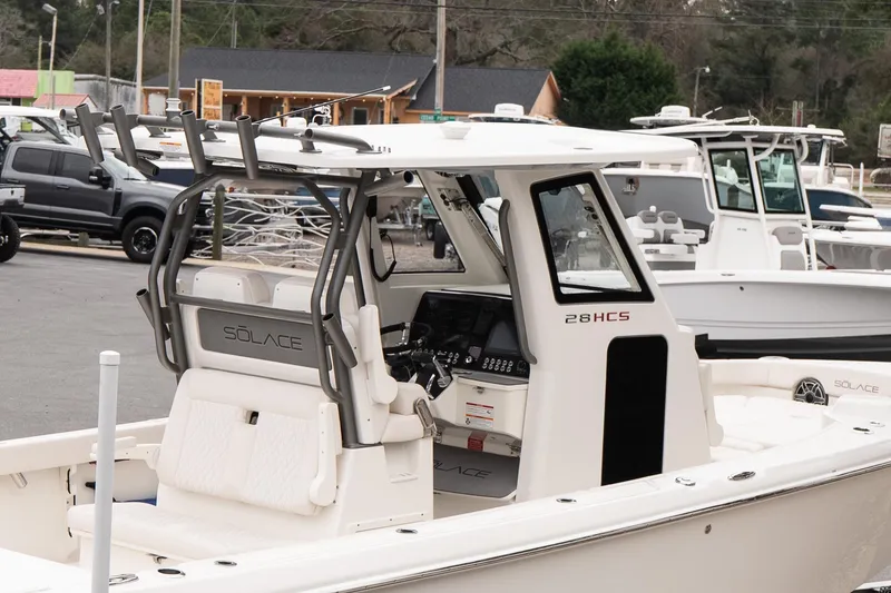 Slide: The Image of 2026 Solace 28 HCS boat with sleek design and modern features, docked outdoors. - 8