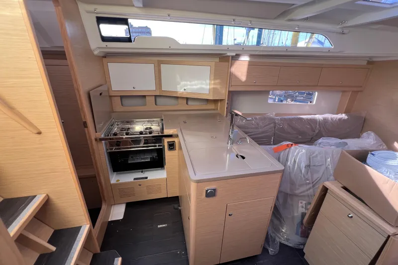 Slide: The Image of Interior of 2026 Dufour 37 yacht, featuring modern kitchen and seating area. - 11