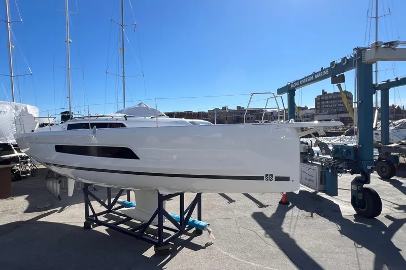 Slide: The Image of 2026 Dufour 37 sailboat on display at a marina under clear blue skies. - 2