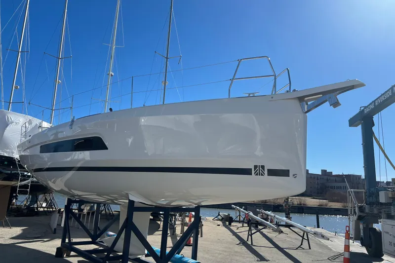 Slide: The Image of 2026 Dufour 37 sailboat on stands, marina background, clear blue sky. - 3