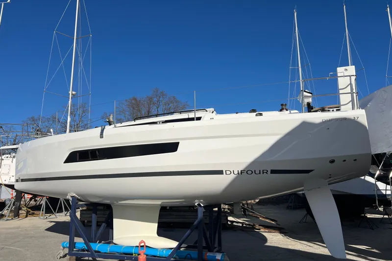 Slide: The Image of 2026 Dufour 37 sailboat on dry dock under clear blue sky. - 5