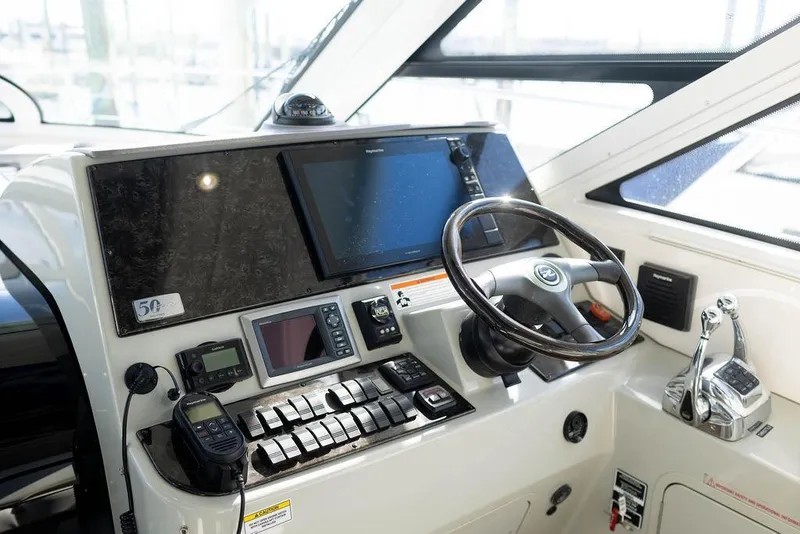 Slide: The Image of 2009 Searay 43 Sundancer helm with navigation controls and steering wheel. - 13