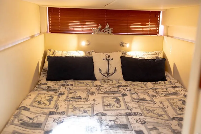 Slide: The Image of Cozy cabin interior of 2009 Searay 43 Sundancer with nautical-themed bedding. - 25