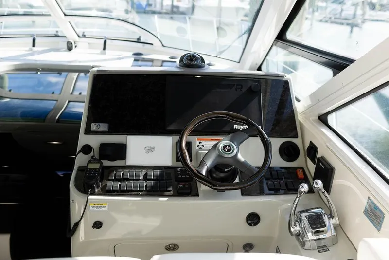 Slide: The Image of 2009 Searay 43 Sundancer helm with steering wheel and navigation controls. - 7