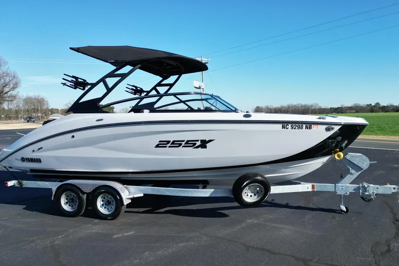 The Image of 2024 Yamaha Boats 255XE on trailer, sleek design, parked outdoors. - 1