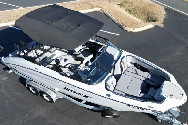 Slide: The Image of 2024 Yamaha Boats 255XE on trailer, featuring sleek design and spacious seating. - 17