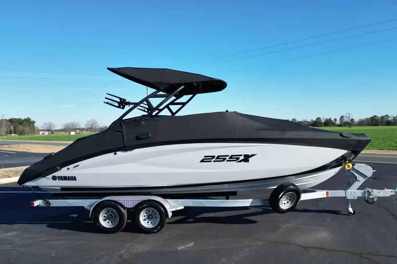 Slide: The Image of 2024 Yamaha Boats 255XE on trailer, covered, with sleek design and dual-axle wheels. - 23