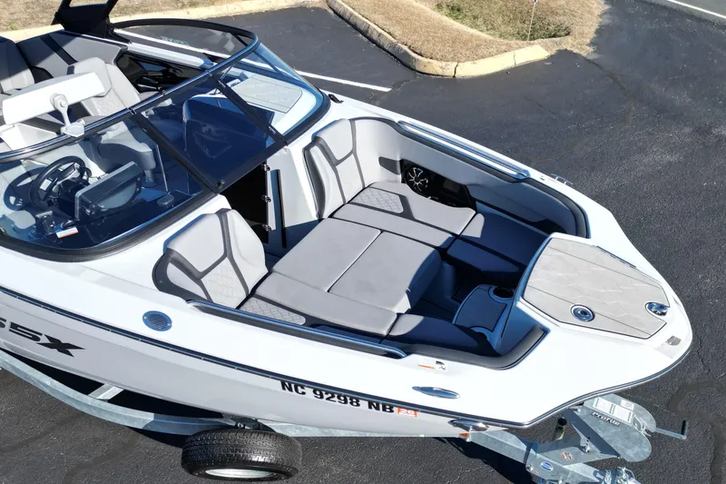Slide: The Image of 2024 Yamaha Boats 255XE, sleek design, spacious seating, parked on trailer. - 6