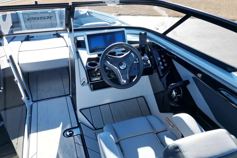 Slide: The Image of 2024 Yamaha Boats 255XE cockpit with modern steering, touchscreen, and sleek interior design. - 13