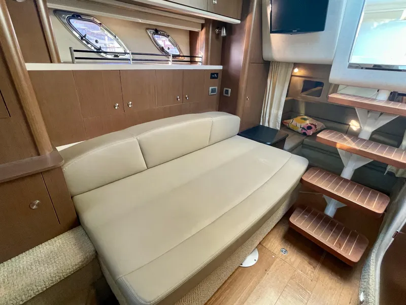 Slide: The Image of Interior of 2014 Sea Ray 330 Sundancer with beige seating and wooden accents. - 13
