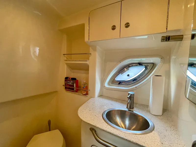 Slide: The Image of 2014 Sea Ray 330 Sundancer bathroom with sink, porthole, and storage cabinets. - 20
