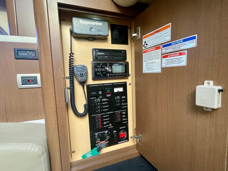 Slide: The Image of Control panel inside 2014 Sea Ray 330 Sundancer boat, featuring Raymarine equipment and safety notices. - 21