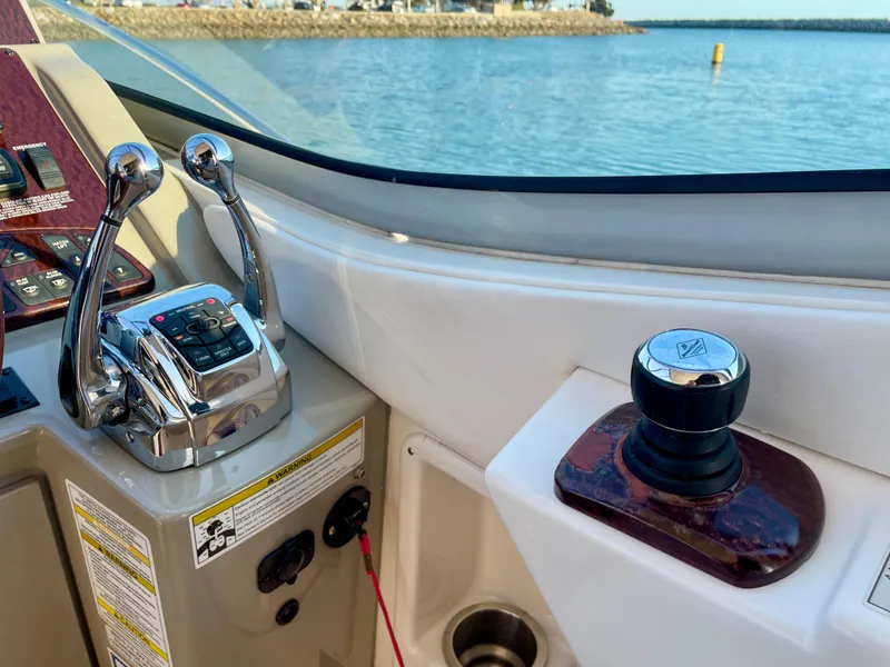 Slide: The Image of Helm controls of 2014 Sea Ray 330 Sundancer with throttle and joystick, overlooking water. - 29