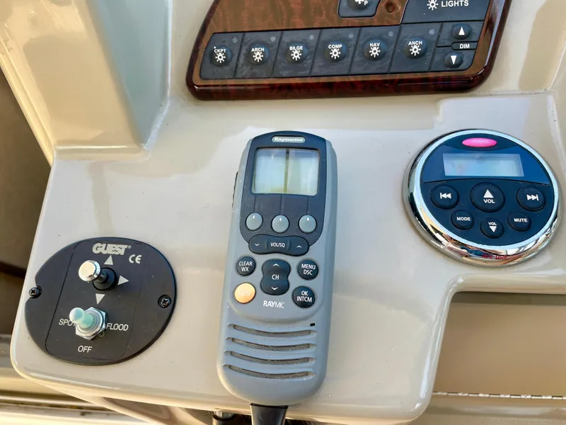 Slide: The Image of Control panel of a 2014 Sea Ray 330 Sundancer boat with various switches and devices. - 33
