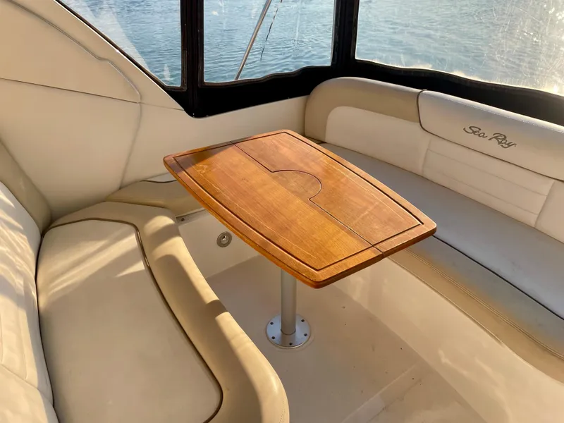 Slide: The Image of 2014 Sea Ray 330 Sundancer interior with wooden table and cushioned seating. - 39