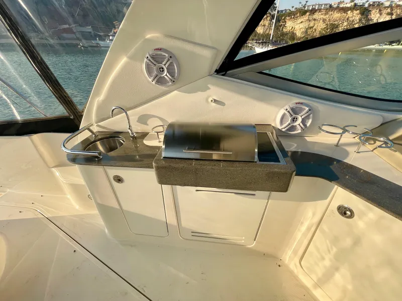 Slide: The Image of 2014 Sea Ray 330 Sundancer boat interior with kitchenette and speakers. - 44