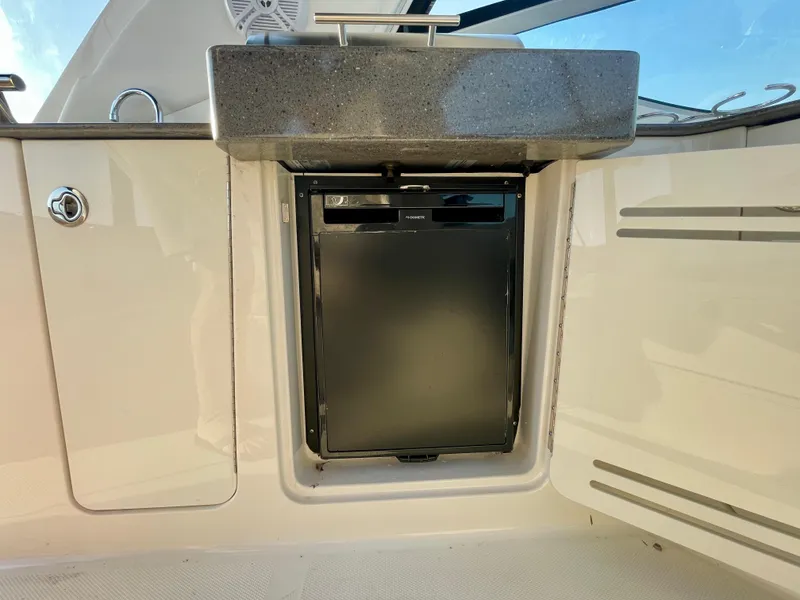 Slide: The Image of 2014 Sea Ray 330 Sundancer boat kitchenette with compact fridge and sink. - 46