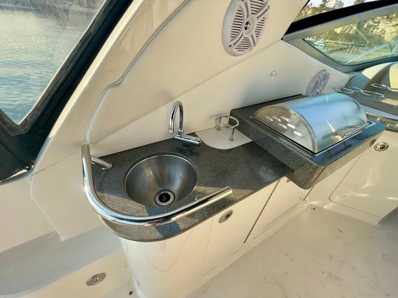 Slide: The Image of 2014 Sea Ray 330 Sundancer yacht kitchenette with sink and covered grill. - 47