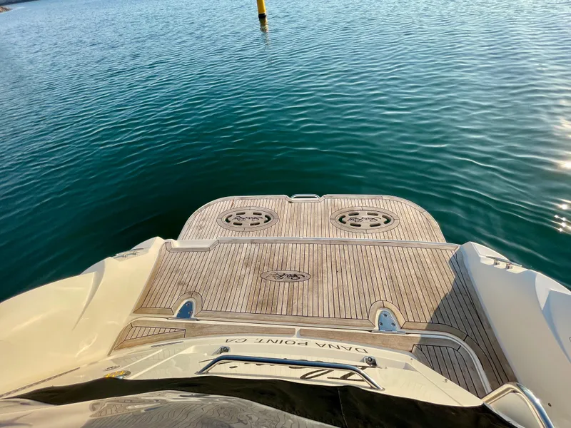 Slide: The Image of 2014 Sea Ray 330 Sundancer boat stern with teak deck on calm water. - 48