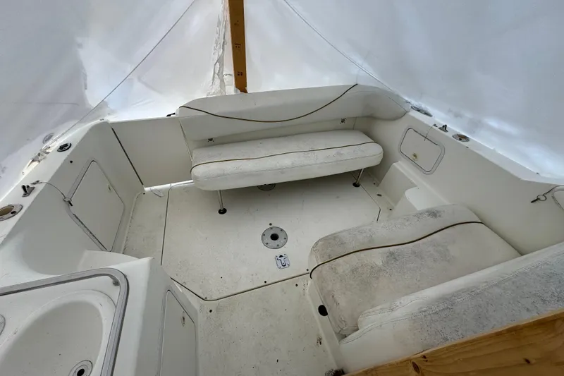 Slide: The Image of 2000 Sea Ray 245 Weekender boat interior with white seating and storage compartments. - 10