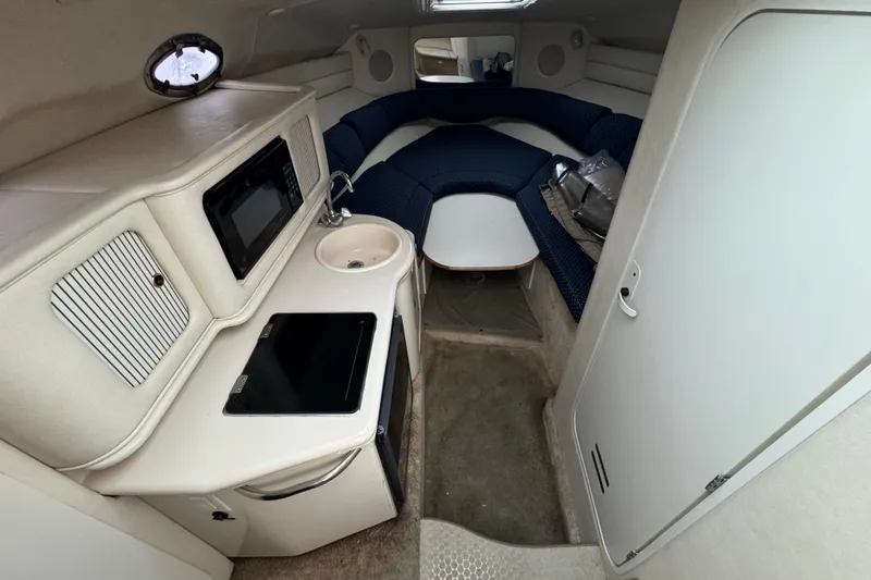Slide: The Image of Interior of 2000 Sea Ray 245 Weekender boat with kitchenette and seating area. - 7