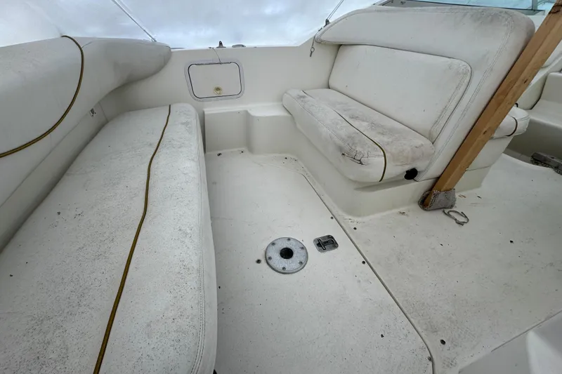 Slide: The Image of 2000 Sea Ray 245 Weekender interior with white seating and deck area. - 9