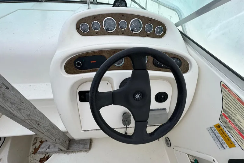 The Image of Steering console of a 2000 Sea Ray 245 Weekender boat with gauges and controls. - 1