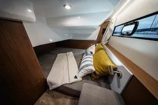Slide: The Image of 2026 Beneteau Antares 9 cabin interior with cozy bedding and window view. - 14