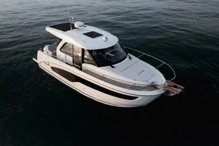 Slide: The Image of 2026 Beneteau Antares 9 boat in scenic coastal waters with people enjoying the sun. - 3