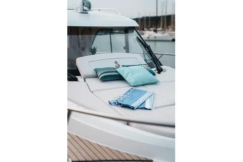 Slide: The Image of 2026 Beneteau Antares 9 boat with cushions on deck, docked in marina. - 7