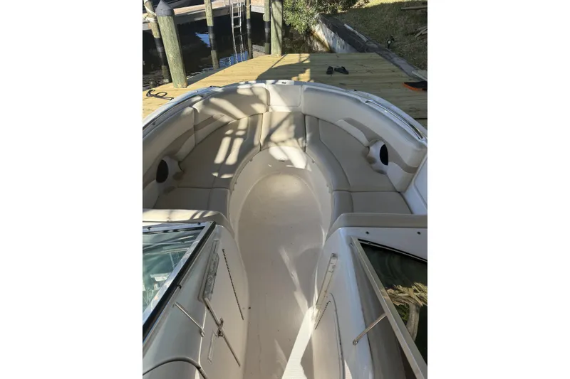 Slide: The Image of 2003 Chaparral Sunesta 263 boat interior with white seating and dock view. - 2