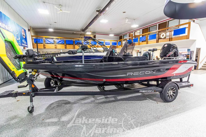 The Image of 2026 Recon 895 DC boat on display in showroom, featuring sleek design and modern features. - 1