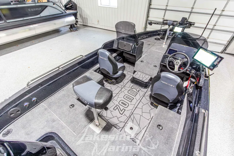 Slide: The Image of 2026 Recon 895 DC boat interior with seating and control panel in showroom. - 12