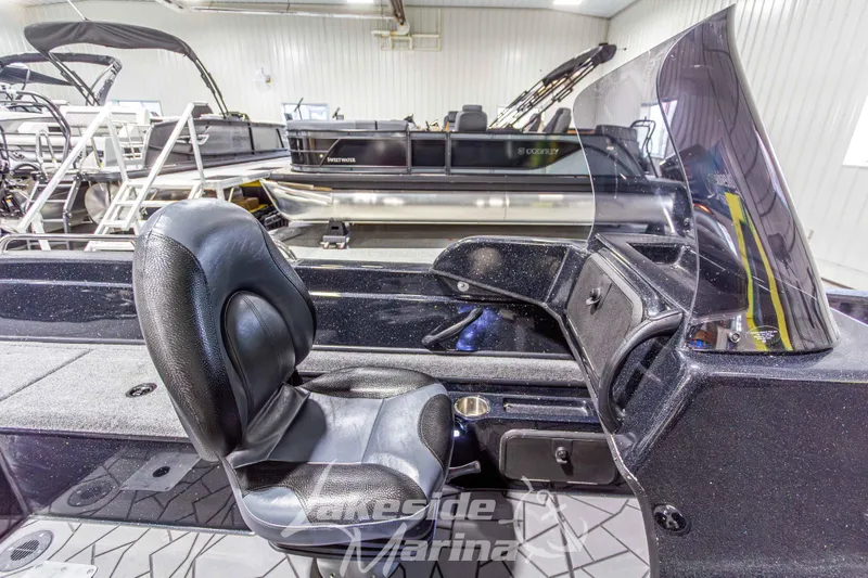Slide: The Image of 2026 Recon 895 DC boat interior with black seat and console in showroom. - 23