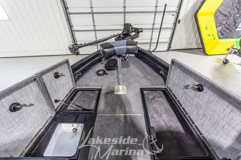 Slide: The Image of 2026 Recon 895 DC boat interior with open storage compartments in a marina setting. - 30